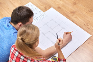 close up of couple with blueprint at home